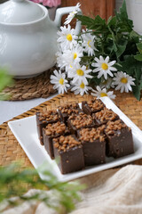 Kuih kole kacang, a steamed Malaysian cake, made with fried green bean flour, coconut milk, and palm sugar.  The decoration of the cake is from coconut oil grease or residue. Selective focus.