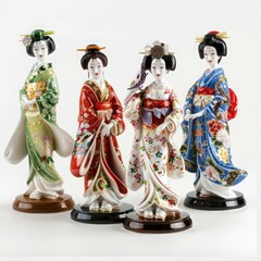 A set of decorative porcelain geisha dolls, isolated on a solid white background