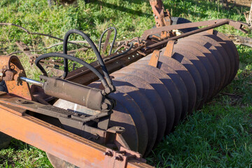 Traditional agricultural practices old disc plow with signs of wear and aging and rusted surface