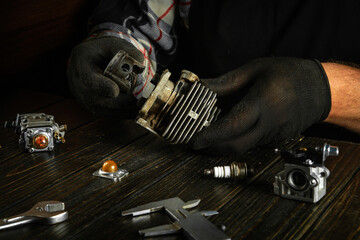 Repair of a scooter engine by a master on a table in a workshop