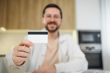 Cheerful blurred man show credit card. Online shopping with banking for payment, sale and cashback