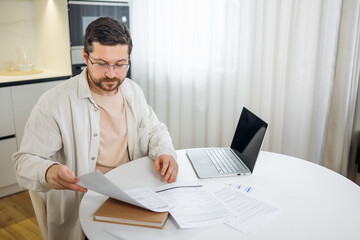 man analyzing income charts and graphs with modern laptop computer work remotely from home....