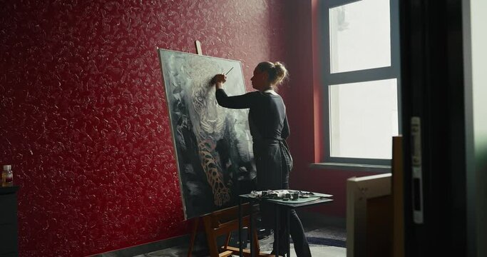 Woman Painting Leopard on Red Studio Wall