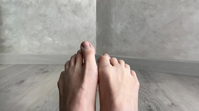 Bare feet showcase flexibility and anatomy, moving toes in various positions on a hardwood floor. Perfect for health and wellness content