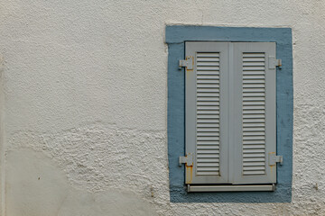 window with shutters is shown against a wall