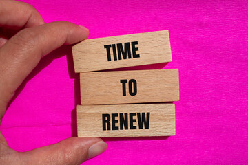 Time to renew words written on wooden blocks with pink background. Conceptual time to renew symbol....