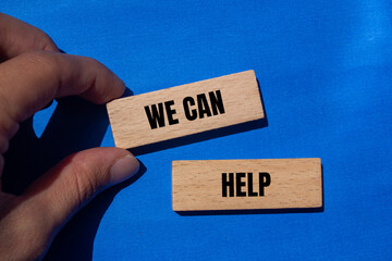 We can help message written on wooden blocks with blue background. Conceptual we can help symbol....