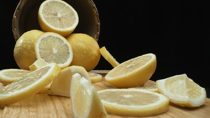 Close up of lemon slices are meticulously arranged against a rustic basket backdrop on a deep black...