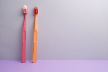 Colored toothbrushes on a color background. Replace your old toothbrush with a new one. Old and new toothbrushes. Dental health and hygiene concept