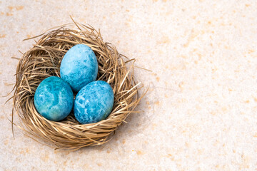 chicken eggs painted blue for Easter on a paper backing, space for text