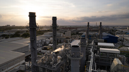 Oil refinery plant chemical factory and power plant with many storage tanks and pipelines at sunset. point of view from a Drone