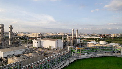 Obraz premium Oil refinery plant chemical factory and power plant with many storage tanks and pipelines at sunset. point of view from a Drone