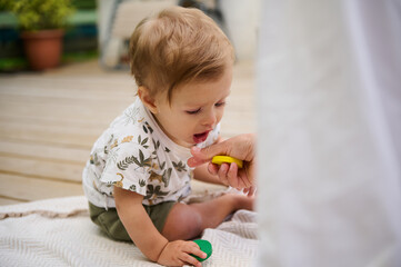 Fototapeta premium Baby playing with toy blocks in outdoor setting