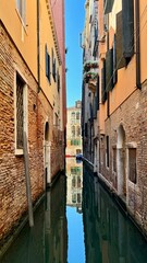 Reflection on the canal with boat at sunset in Venice, Italy