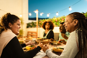 Happy African family dining together on house patio