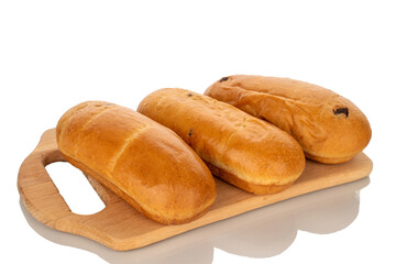 Three fragrant buns on a wooden kitchen board, close-up, isolated on a white background.