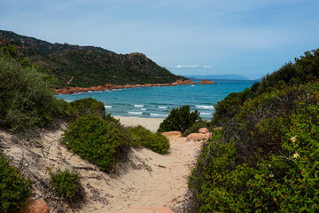 Sandy path to wild hidden Su Sirboni beach and red rock formations on Sardinia (Sardegna) island in Italy. Tyrrhenian Sea.