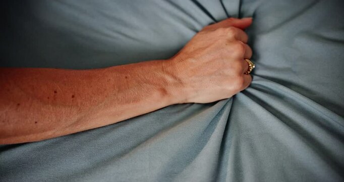Closeup, hand and woman grab sheet, fabric and love with expression, ecstasy and passion. Person, bedroom and girl with material, linen and intimacy with honeymoon, fingers on blanket and romance