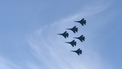 Aviation fighters fly synchronously in the sky. Piloting Mig jets on parade.
