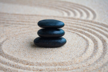 Black zen stones inside lines carved on sand with customizable space for text