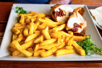 French fries with chicken roulade with dried tomato, sprouted pea leaf.