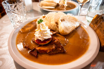 Venison meat in spicy sauce with dumpling and cream.