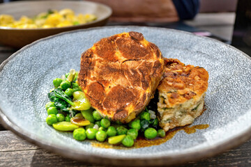 Grilled pork collar neck steak, stewed fava beans and pea and baked stuffing.