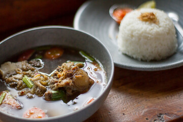 Sop Buntut or oxtail soup on a wooden table. traditional Indonesian culinary delights