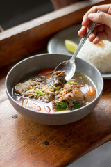 Sop Buntut or oxtail soup on a wooden table. traditional Indonesian culinary delights