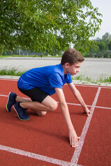 An athlete stands on the starting line at the stadium.
