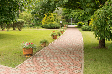 Obraz premium a beautiful and well-kept park with paths of fir trees and flowers