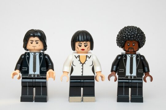Lego minifigures dressed in black suits and white shirts standing in a row on a white background