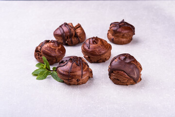 Delicious eclair covered with chocolate isolated on white, top view