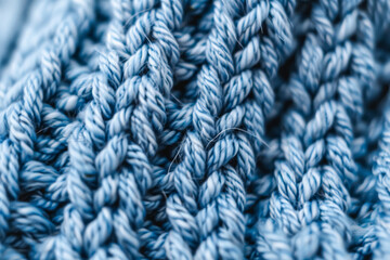 A close up of a blue knit sweater with a fuzzy texture