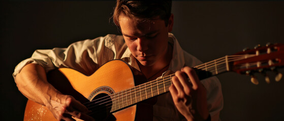 Obraz premium A focused musician intensely strums an acoustic guitar, enveloped in warm lighting that highlights his dedication and passion for the art of music.