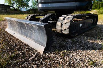 Bucket and rubber crawler tracks of a small excavator close-up