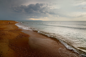 Sandy shell deserted beach in cloudy weather after rain. Buoys with rope to delimit the beach area