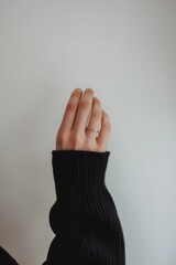 Isolated white backdrop with a hand holding a ring on it.