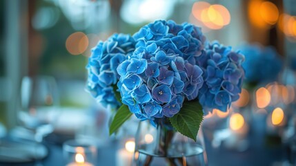 Stunning close-up of a blue hydrangea bouquet set against the backdrop of a candlelit event. The lush flowers create a striking visual, embodying the elegance of the occasion.