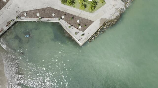 Drone flies up with camera down over ruins next to Marco dos Corais in Maceio, Alagoas, Brazil