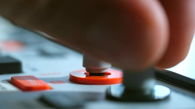 Man deftly presses and twists buttons on control panel in studio. Each action contributes to smooth operation and seamless production environment