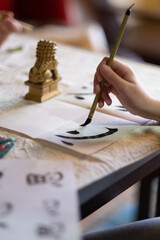Persona escribiendo caligrafía japonesa con pincel