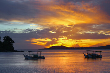 Boats at the coast of a tropical island during colorful sunset © Vladimir