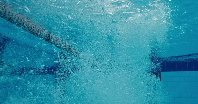 Underwater, dive and male athlete for pool exercise, training and cardio for practice. Stroke, professional or start for competition or splash with movement, sports or workout for health and wellness