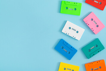 Colorful pattern made of retro audio cassette tapes on blue background with copy space. Creative concept of retro technology. 80's aesthetic retro style. Vintage cassette tape pattern idea. Flat lay.