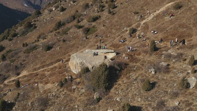 Aerial view of famous Broken Heart stone with group of tourists in Ala Archa National park in Kyrgyzstan