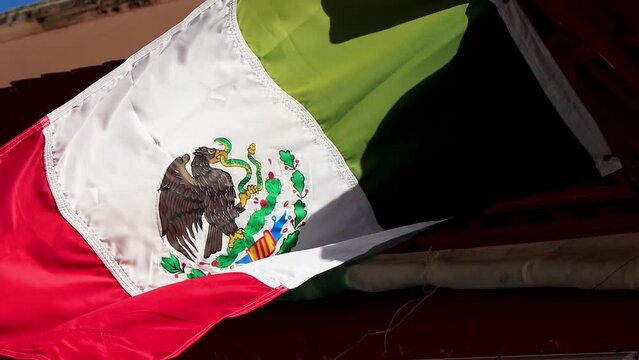 Mexican green white red flag waves in wind in Mexico.