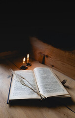 Open Bible in Rustic Scene with Rye and Candles Burning on a Wooden Table Top with Copy Space