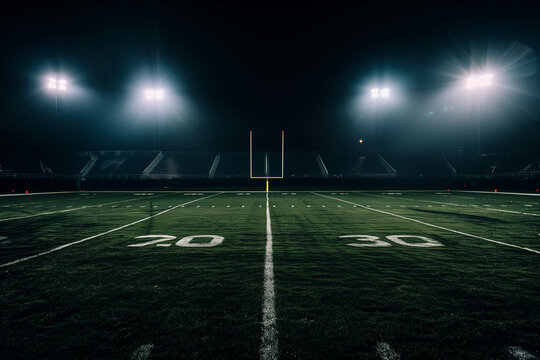 A dimly lit football field with bright stadium lights creating a dramatic spotlight effect against the dark background 