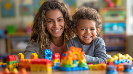smiling female teacher and preschool child playing together with colorful toys  at kindergarten